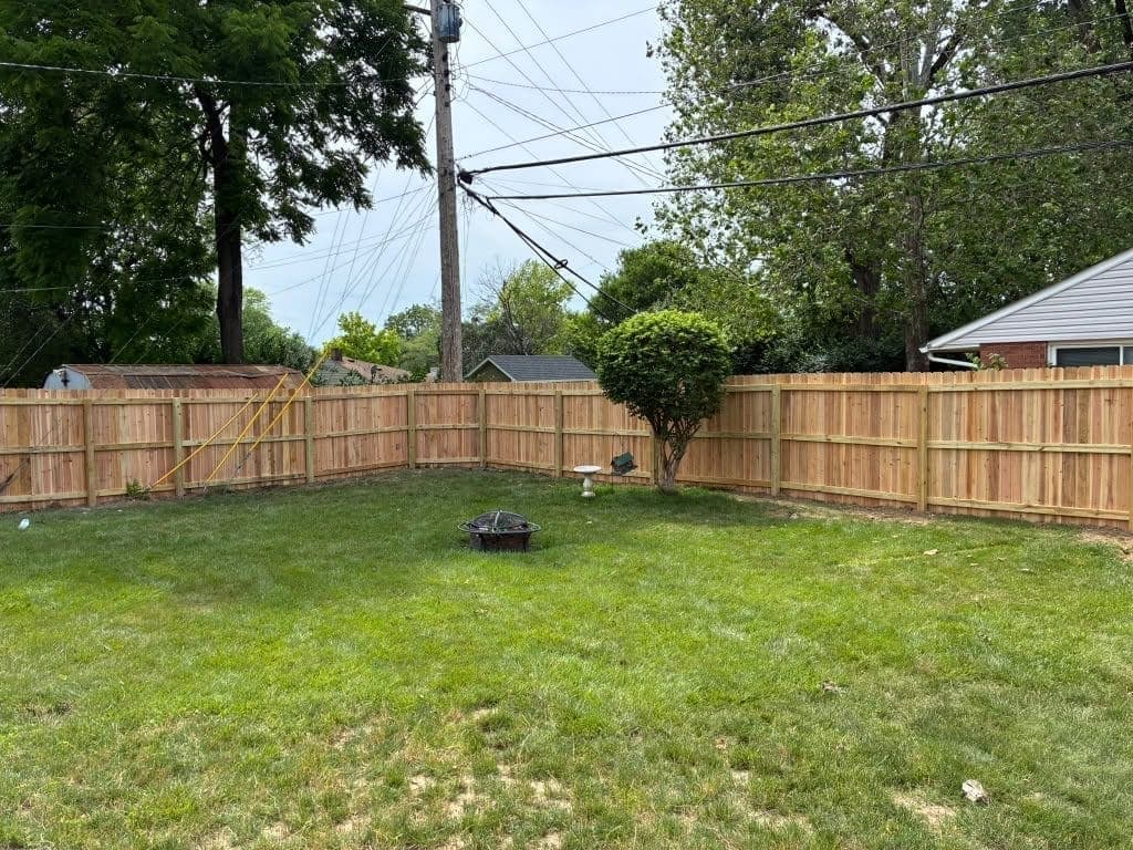 Wood privacy fence enclosing a backyard firepit area